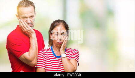 Mittleres Alter spanischer Paar in Liebe über isolierte Hintergrund denken müde und mit Depressionen Probleme mit verschränkten Armen gelangweilt. Stockfoto