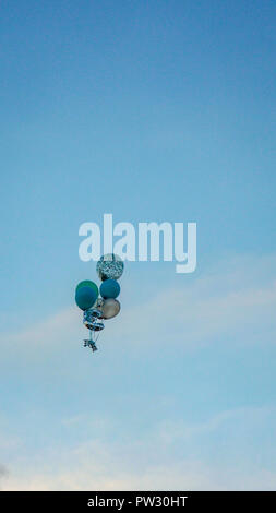 Globus mit Helium schwimmenden gegen den Himmel in Schwarz und Weiß Stockfoto