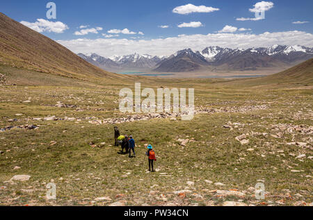 Trekker Abstieg von 4.800 m Bel Airyk Pass mit Zorkul See im Hintergrund auf Trek von Keng Shiber Kara Jilga, Pamir, Tadschikistan. Stockfoto