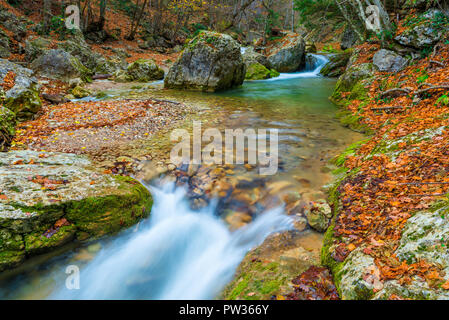 Mountain River fließt unter großen Steinen in die Berge im Herbst, schöne Landschaft Stockfoto