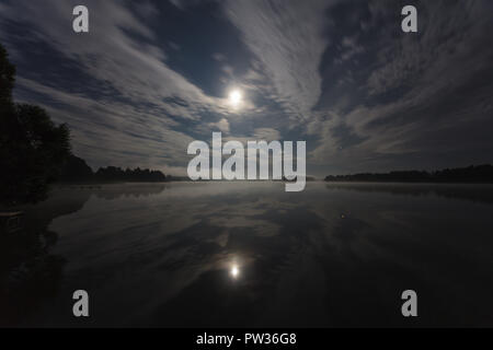 Wolken in der Nacht über den See leuchtet bei Vollmond, Langzeitbelichtung Schuss Stockfoto