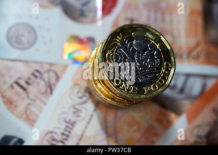 Stapel von Pfund Münzen auf Kunststoff zehn Pfund Noten Stockfoto