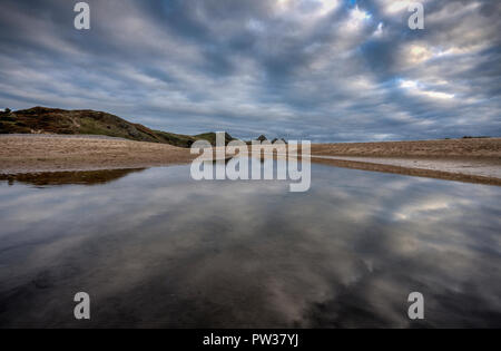 Reflexionen an Three Cliffs Bay Stockfoto