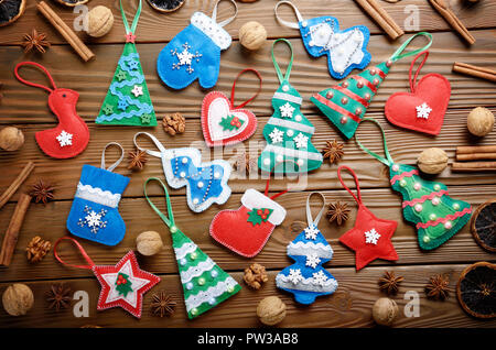 Verschiedene handgefertigte rustikalen fühlte Christbaumschmuck mit Anis, Zimt und Walnüssen auf hölzernen Tisch Stockfoto