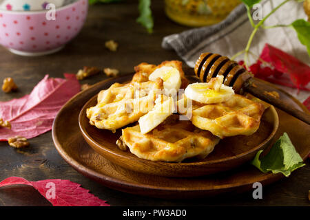 Thanksgiving backen. Belgische Nussbaum Wafer auf einer hölzernen Küchentisch, serviert mit frischem Bananenscheiben und Honig. Stockfoto