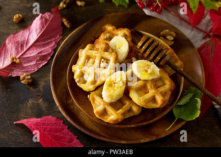 Thanksgiving backen. Belgische Nussbaum Wafer auf einer hölzernen Küchentisch, serviert mit frischem Bananenscheiben und Honig. Kopieren Sie Platz. Stockfoto