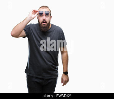 Junge kaukasier hipster Mann mit Sonnenbrille über isolierte Hintergrund Angst und mit Erstaunen Ausdruck, Angst und aufgeregt Gesicht schockiert. Stockfoto