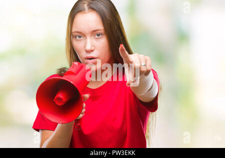 Junge kaukasier Frau schreiend durch Megafon über isolierte Hintergrund mit dem Finger an die Kamera und an Sie gerichtet, Handzeichen, positiv und confid Stockfoto