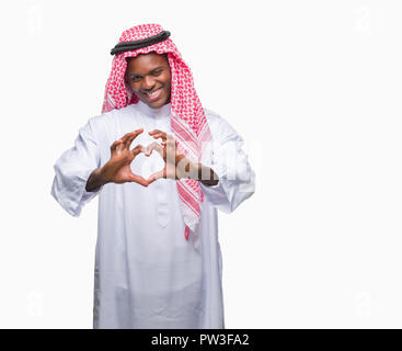 Junge arabische afrikanischen Mann mit traditionellen Kufiya über isolierte Hintergrund in der Liebe mit Herz und mit Hand lächelnd. Romantische con Stockfoto