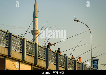 Fischer von der Galatabrücke bei Sonnenuntergang mit Minaretten im Hintergrund, Istanbul, Türkei Stockfoto