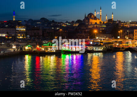 Die hell erleuchtete schwebende Küche Boote von eminönü mit Suleymaniye Moschee und das Goldene Horn im Hintergrund bei Dämmerung, Istanbul, Türkei Stockfoto