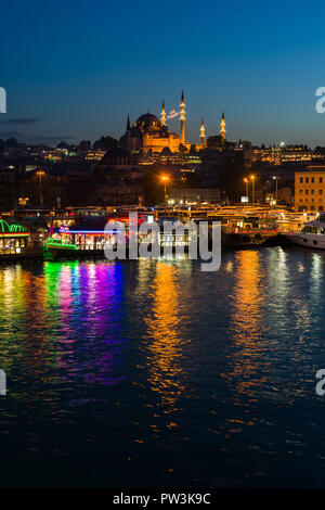 Die hell erleuchtete schwebende Küche Boote von eminönü mit Suleymaniye Moschee und das Goldene Horn im Hintergrund bei Dämmerung, Istanbul, Türkei Stockfoto