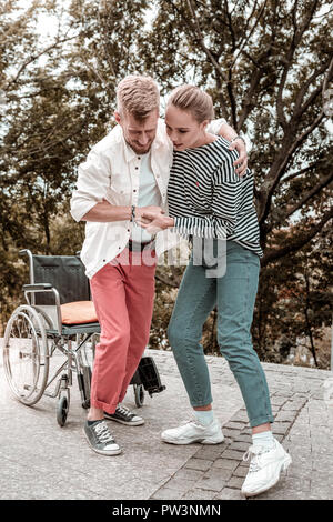 Behinderte Menschen Gefühl Schmerz beim Versuch, vom Rollstuhl zu stehen Stockfoto