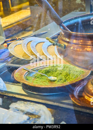 Kunefe, auch als Kenafeh, einem traditionellen arabischen Dessert mit Kadayif, einem dünnen Teig Nudel, über Holzkohle Grill eines Straße bekannt. Istanbul. Stockfoto