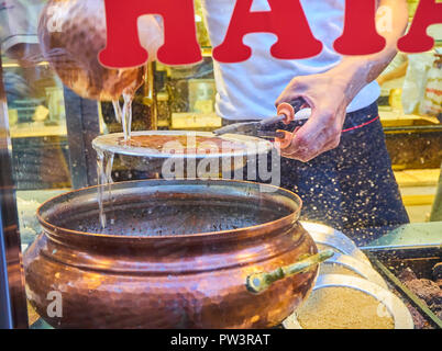 Kunefe, auch als Kenafeh, einem traditionellen arabischen Dessert mit Kadayif, einem dünnen Teig Nudel, über Holzkohle Grill eines Straße bekannt. Istanbul. Stockfoto