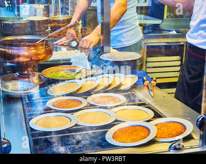 Kunefe, auch als Kenafeh, einem traditionellen arabischen Dessert mit Kadayif, einem dünnen Teig Nudel, über Holzkohle Grill eines Straße bekannt. Istanbul. Stockfoto