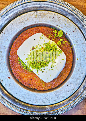 Kunefe, auch als Kenafeh, traditionelle arabische Dessert mit Kadayif, einem dünnen Teig Nudeln bekannt, in Sirup getränkten, mit Eis und Pistazien Layered Stockfoto