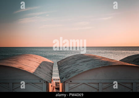 Details von den schönen weißen Strand Hütten in Europa. Windig, sonnigen Tag, Blau Trübe Stimmung, winter Sonnenuntergang bis Abenddämmerung Moment. Ruhiger Tag, geschwungene Dächer. Stockfoto