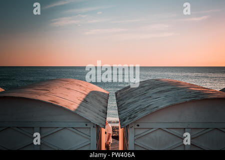 Details von den schönen weißen Strand Hütten in Europa. Windig, sonnigen Tag, Blau Trübe Stimmung, winter Sonnenuntergang bis Abenddämmerung Moment. Ruhiger Tag, geschwungene Dächer. Stockfoto