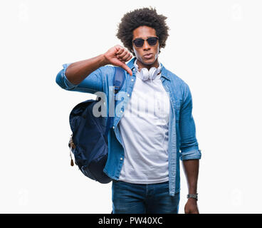 Afro-amerikanischer Mann mit Kopfhörern und Rucksack über isolierte Hintergrund mit Verärgerten Gesicht, negatives Vorzeichen zeigen Abneigung mit Daumen nach unten, Ablehnung Stockfoto