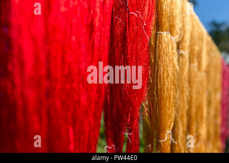 Bunte Stoff hängend trocknen nach dem traditionellen Farbstoff standardprocesss in Luang Prabang, Laos. Seidenproduktion Fabrik. Traditionelle Herstellung in Asien. Stockfoto