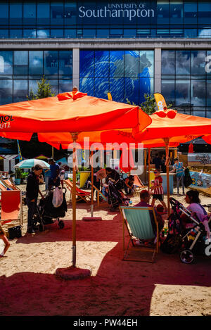 Eltern und Mitarbeiter gleichermaßen genießen Sie die Sonne und die erste Gebaut' Strand entspannen" in der neuen kulturellen Viertel in der Mitte des C Stockfoto