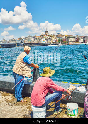 Bürger Angeln in Eminonu Pier mit Blick auf den Stadtteil Karakoy Skyline im Hintergrund. Istanbul, Türkei. Stockfoto