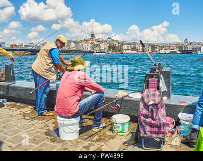 Bürger Angeln in Eminonu Pier mit Blick auf den Stadtteil Karakoy Skyline im Hintergrund. Istanbul, Türkei. Stockfoto