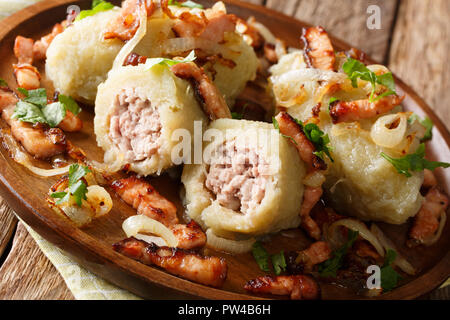Leckere litauische Klöße mit Fleisch mit Speck und gebratenen Zwiebeln in der Nähe serviert auf einem Teller auf den Tisch. Horizontale Stockfoto