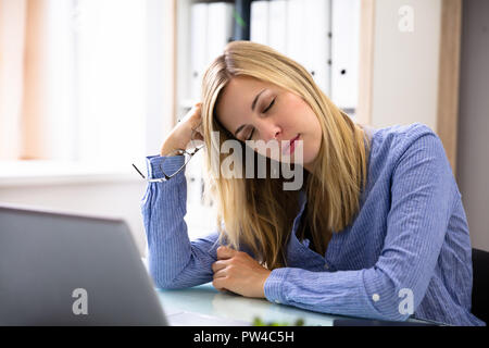 Foto von schönen jungen Geschäftsfrau schlafen im Büro Stockfoto