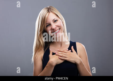 Portrait eines glücklichen jungen Frau auf grauem Hintergrund Stockfoto