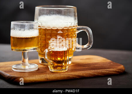 Drei golden delicious Biere auf einem alten schwarzen Holztisch in einem Pub Stockfoto