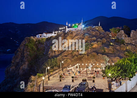 Nachtansicht von Kastro, das Schloss von Skopelos Stadt, Insel Skopelos, Sporaden, Griechenland. Oben sehen Sie "Anatoli' Taverne, während unterhalb der Taverne "ylos'. Stockfoto