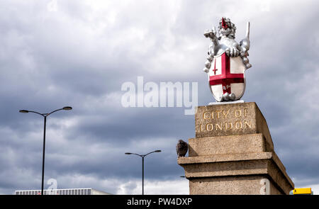 Low Angle View von dragon Statue mit Schild und St. George's Cross gegen bewölkter Himmel Stockfoto