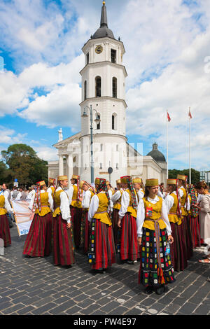 Litauisches Festival, Blick auf junge Frauen in traditionellen Kostümen, die darauf warten, beim Song and Dance Festival in Vilnius über den Kathedralenplatz zu fahren. Stockfoto