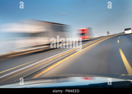 Verschwommene Bewegung von Fahrzeugen, die auf der Straße durch Auto Windschutzscheibe gesehen Stockfoto