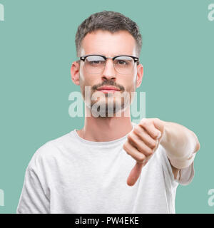 Junge tätowiert erwachsenen Mann suchen unzufrieden und wütend, Ablehnung und negativ mit Daumen nach unten Geste. Schlechter Ausdruck. Stockfoto