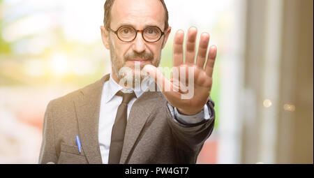 Lehrer Mann mit Brille mit schlechter Haltung, STOP-Schild mit Hand genervt, nein zu sagen, und die Sicherheit, die Verteidigung oder Beschränkung, vielleicht drücken Stockfoto