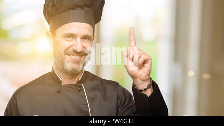 Senior cook Mann mit Koch hat die Finger, die Nummer eins Stockfoto