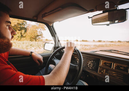 Seitenansicht des bärtigen Mann im Oldtimer sitzen Stockfoto