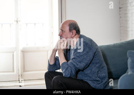 Alte ältere Menschen leiden allein zu Hause Gefühl überwältigt verwirrt traurig alleine auf der Couch zu Hause in alternden Ruhestand Witwer Demenz und Alzheimer conc Stockfoto