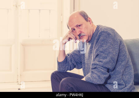 Alte ältere Menschen leiden allein zu Hause Gefühl überwältigt verwirrt traurig alleine auf der Couch zu Hause in alternden Ruhestand Witwer Demenz und Alzheimer conc Stockfoto