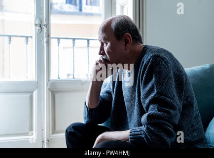 Alte ältere Menschen leiden allein zu Hause Gefühl überwältigt verwirrt traurig alleine auf der Couch zu Hause in alternden Ruhestand Witwer Demenz und Alzheimer conc Stockfoto