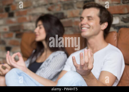 Mann und Frau Meditieren auf der Couch zu Hause sitzen Stockfoto