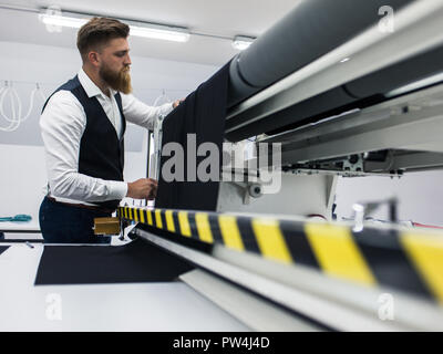 Junge Bartgeier maßgeschneiderte arbeiten an neuen Kleidung Design Stockfoto