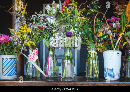 Blumen in der Vase - Blumensträuße in Gläsern auf dem Tisch - Stockfoto