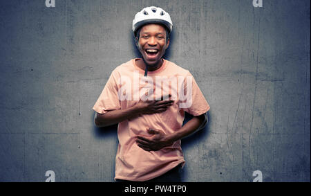Schwarzer Mann mit Fahrrad Helm zuversichtlich und zufrieden mit einen großen natürlichen Lächeln Lachen Stockfoto