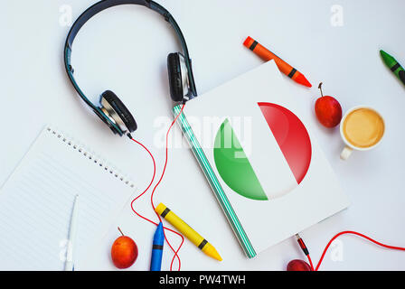 Das Buch mit italienischer Flagge und Kopfhörer. Konzept der Italienisch lernen durch Audio- kurse Stockfoto