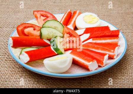 Mit Crab Sticks Platte, gekochten Eiern und frisch Tomaten und Gurke auf Sack in Scheiben geschnitten Stockfoto