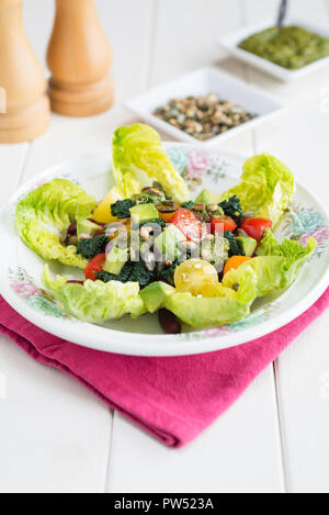 Dreifarbige Salat mit Bohnen, Tomaten, Kohl und Avocado auf einem Bett von Juwel Kopfsalat. Stockfoto